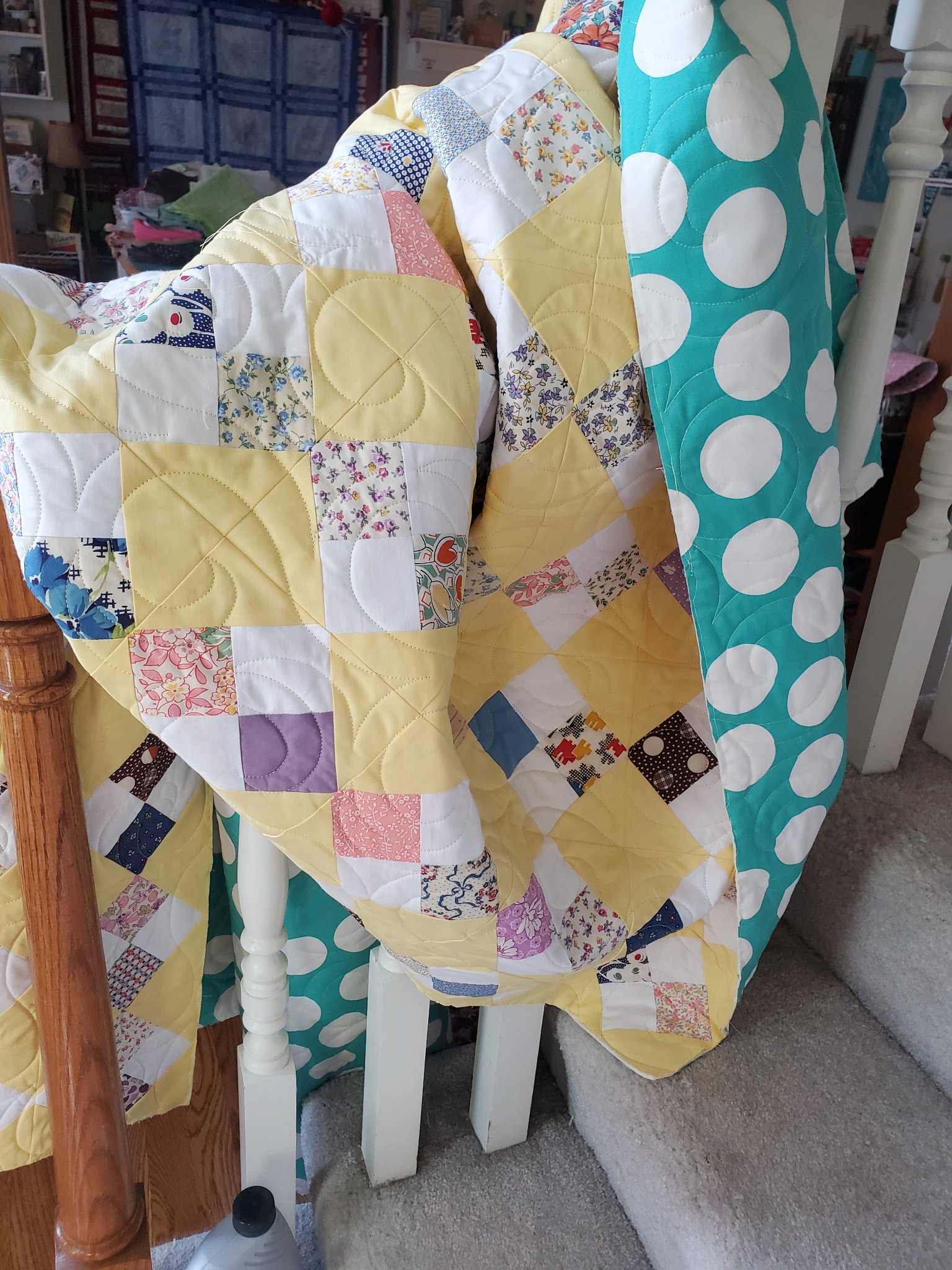 Colorful blue and green quilt loaded on the longarm frame